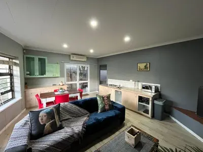 a living room with a couch and a kitchen at Queens Corner in Wellington