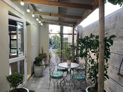 a patio with a table and chairs on a patio at Queens Corner in Wellington