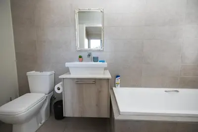 a bathroom with a sink and a toilet and a mirror at Family Suite-Two Bedroom Waters Edge in Cape Town