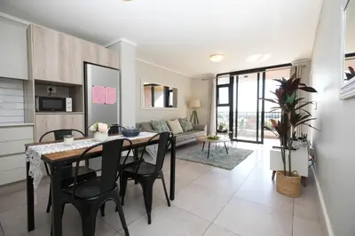 a kitchen and dining room with a table and chairs at Family Suite-Two Bedroom Waters Edge in Cape Town