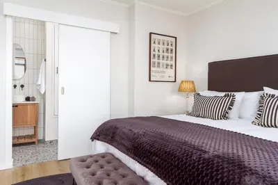 a bedroom with a large bed with a brown blanket at Luxurious Palm View Apartment Cape Town in Cape Town