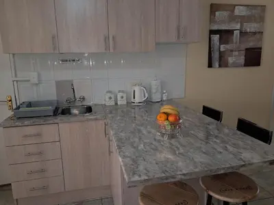 a kitchen with a counter with a bowl of fruit on it at Deo Volente Self-Catering Cottage in Kuilsrivier