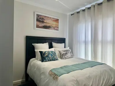 a bedroom with a bed with pillows and a window at DRJ Luxe Table view in Table View