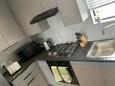 a small kitchen with a stove and a sink at DRJ Luxe Table view in Table View