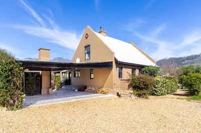 a large yellow house with a roof at Franschhoek Charm in Franschhoek