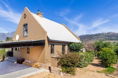 a house with a snow covered roof on top of it at Franschhoek Charm in Franschhoek