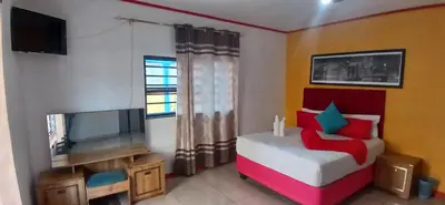 a bedroom with a bed and a flat screen tv at Goodwood Neo & Ruks guest house in Goodwood