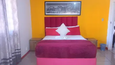 a bedroom with a bed with red and yellow walls at Parow Neo & Ruks Rooms 9 in Avondale