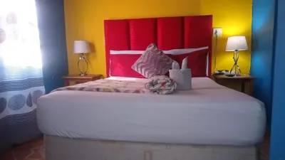 a bedroom with a large bed with a red headboard at Parow Neo & Ruks Rooms 9 in Avondale