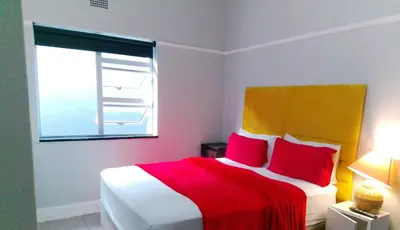 a bedroom with a red and white bed with a window at Parow Neo & Ruks Rooms 9 in Avondale