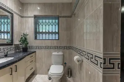 a bathroom with a toilet and a sink at TwinPalace in Plattekloof