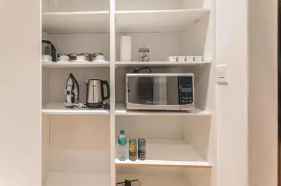 a white pantry with a microwave in it at TwinPalace in Plattekloof