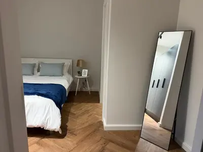 a bedroom with a bed and a mirror at Luxe 1br apartment on Park in Cape Town