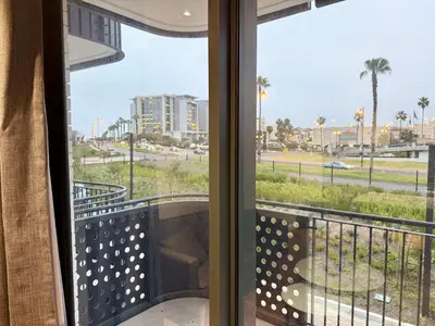 a balcony with a view of the beach and palm trees at Luxe 1br apartment on Park in Cape Town