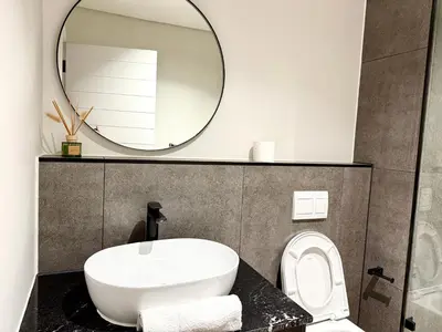a bathroom with a white sink and a mirror at Luxe 1br apartment on Park in Cape Town