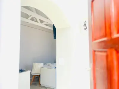 a room with a bed and a desk and a door at Bahlaloga Studio Durbanville in Durbanville