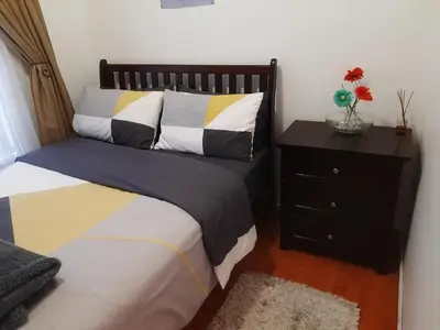 a bedroom with a bed and a nightstand with a bed sidx sidx at Local & Comfortable in Mandalay