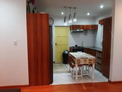 a kitchen with a table and a yellow door at Local & Comfortable in Mandalay