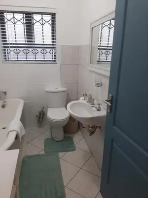 a white bathroom with a toilet and a sink at Local & Comfortable in Mandalay