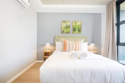 a bedroom with a white bed with two towels on it at Riverlands - Mountain View 1-BR Premium Apartment in Cape Town