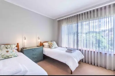 a bedroom with two beds and a large window at Akasia 1 in Caledon
