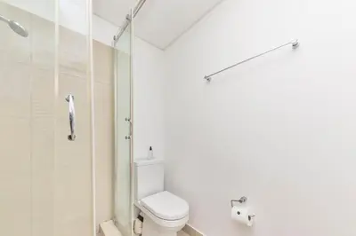 a white bathroom with a toilet and a shower at Horizon Bay 201-Beachfront Gem Table Mtn in Cape Town