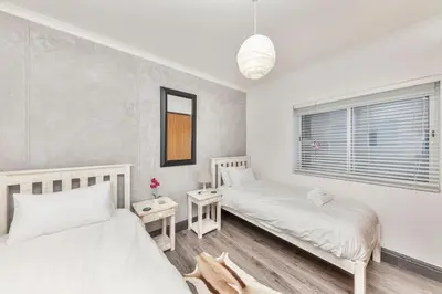 a bedroom with two beds and a window at Horizon Bay 201-Beachfront Gem Table Mtn in Cape Town
