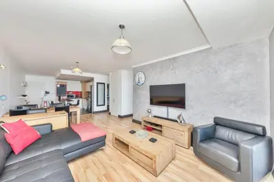 a living room with a couch and a tv at Horizon Bay 201-Beachfront Gem Table Mtn in Cape Town