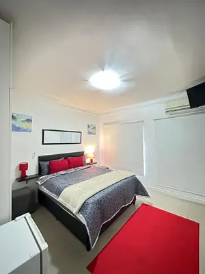 a bedroom with a bed and a red rug at Surrey B&B in Surrey Estate