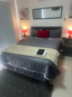 a bedroom with a bed with a tablet on it at Surrey B&B in Surrey Estate