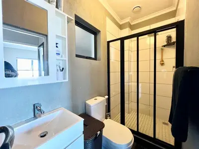a bathroom with a toilet and a sink and a shower at Cape on Porterfield in Cape Town