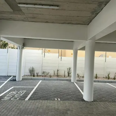 an empty parking lot with columns and a white wall at DRJ Luxe in Cape Town