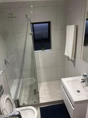 a bathroom with a shower and a toilet and a sink at DRJ Luxe in Cape Town