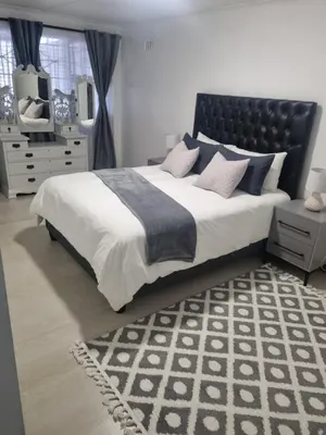 a bedroom with a large bed with a black headboard at 4 Jooste Street in Windsor Park