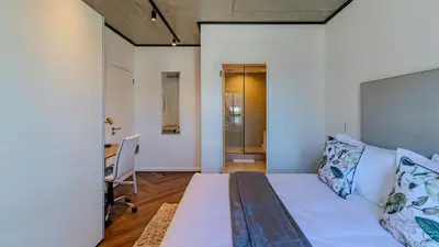 a bedroom with a bed and a desk in a room at The Bridgewater collection 411 in Cape Town