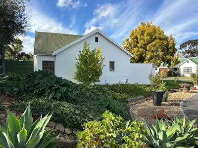 a white house with a landscaping at Rose Garden, a Self-catering cottage in Worcester