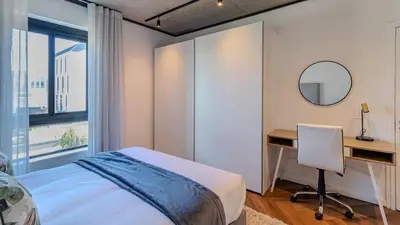 a bedroom with a bed and a desk and a mirror at The Bridgewater collection 411- Luxury 1 bed Morden Apartment at Century City in Cape Town