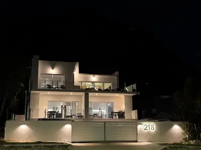 a large white house at night with lights at Peach On Beach Boutique Apartments in Hermanus