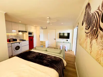 a small room with a bed and a kitchen at Peach On Beach Boutique Apartments in Hermanus