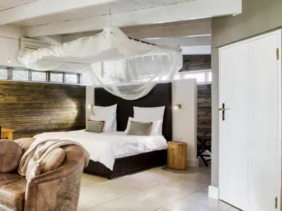 a bedroom with a large bed with a canopy at The Residence Boutique Hotel in Grabouw