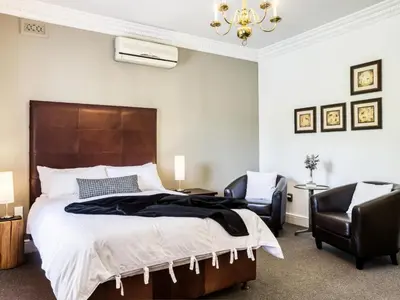 a bedroom with a large bed and two chairs at The Residence Boutique Hotel in Grabouw