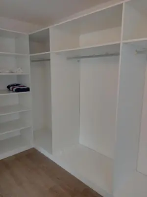 a walk in closet with white walls and wooden floors at Mountain View in Hermanus