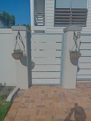 a white fence with two potted plants on it at Mountain View in Hermanus