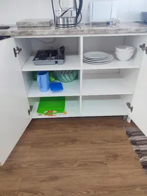 a kitchen cabinet with white shelves and a wooden floor at Birds Holiday Accommodation 1 in Zeekoevlei