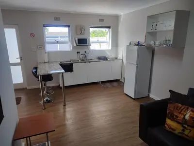 a small kitchen with a sink and a refrigerator at Birds Holiday Accommodation 1 in Zeekoevlei