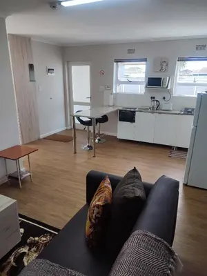 a living room with a couch and a kitchen at Birds Holiday Accommodation 1 in Zeekoevlei