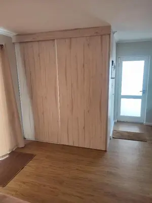 a large wooden door in a room with a wooden floor at Birds Holiday Accommodation 1 in Zeekoevlei