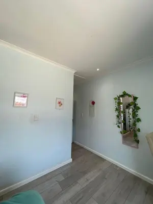 a living room with white walls and a mirror at Western Cape in Cape Town