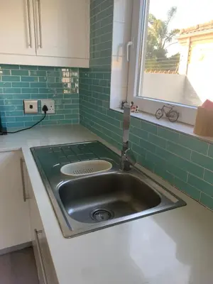 a sink in a kitchen with green tile at Western Cape in Cape Town