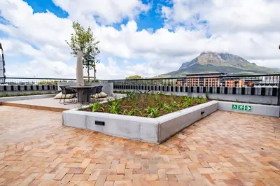 a patio with a table and a view of a mountain at 507 Riverlands - Lux Studio Apartment in Cape Town